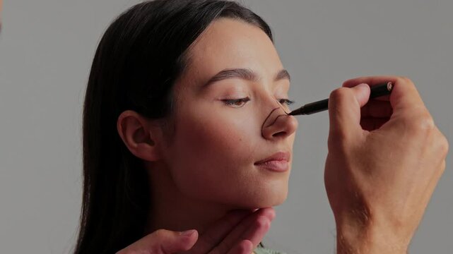 Rhinoplasty surgery to change shape and size of nose 4k video. Doctor is marking plan of nose surgery for accurate result. Young girl wants to correct birth defect of her nose.