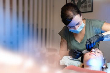 Beauty Close-up of a young woman having her eyelashes lash lifting enhanced with an eyelash lift by...