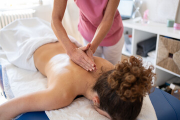 Professional masseuse massaging back with special technique