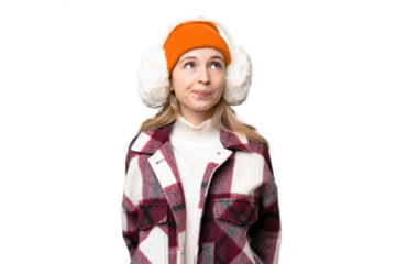 Young  English woman wearing winter muffs over isolated background and looking up
