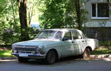 Naklejka premium An old rusty Soviet car at the entrance of a residential building, Tovarischeskiy Prospekt, Saint Petersburg, Russia, June 27, 2024
