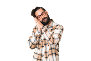 Young man with beard over isolated chroma key background making sleep gesture in dorable expression