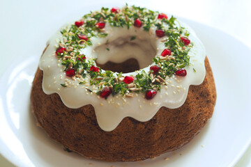 A beautifully decorated vegan bundt cake in a Prague café, topped with glaze, fresh herbs, pomegranate, and sunflower seeds. This plant-based dessert is both visually stunning and delicious.