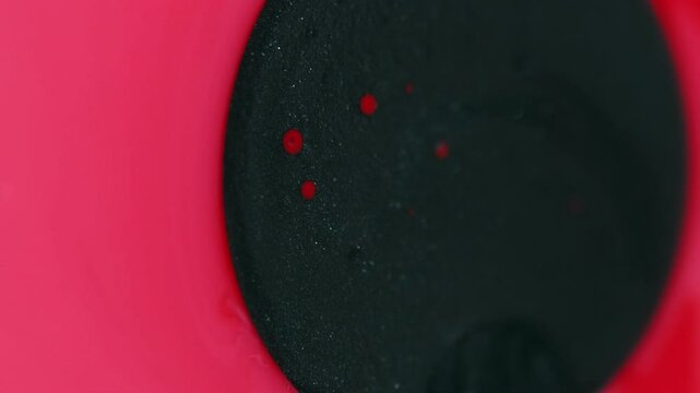 Glitter drop. Ink flow. Defocused coral pink black color shimmering stain absorption glossy liquid oil bubbles float smooth texture abstract art background.