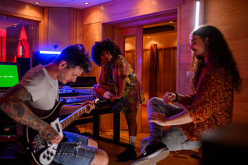 Hispanic woman producer listening musicians playing while working in a studio