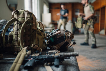 Close up of airsoft gear and equipment with players in background