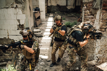 Air soft team in action at abandoned building shooting at opponent.