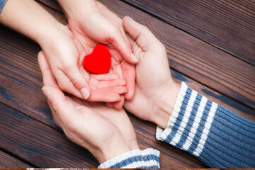 A Heart in hands on valentine's day on a wooden background holiday