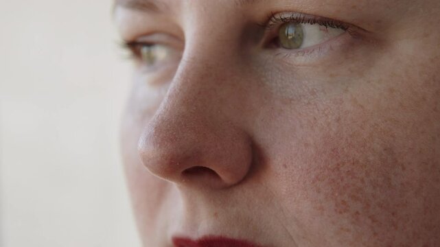 Portrait of caucasian woman wrinkles nose close up on face. Skin folds and wrinkles near eyes and disgust emotion in person with freckles.