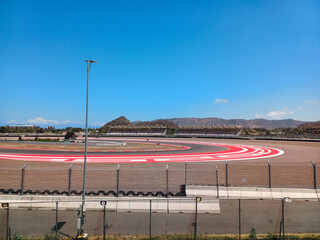 a race track with a fence and a hill in the backround, mandalika mandalika circuit