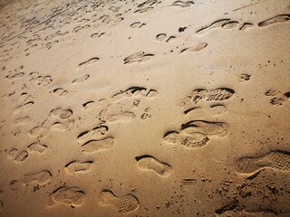 Fußabdrücke auf nassem Sand - kreuz und quer
