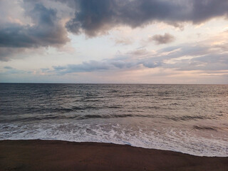 Waves crashing on a beach at sunset