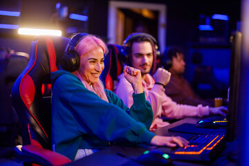 Smiling gamer girl with headset is winning pvp competition in cybercafe © Zamrznuti tonovi