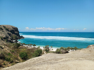 a rock cliff with waves crashing on the shore, Cliff overlooking beach, senggigi beach, Beach in West Nusa Tenggara