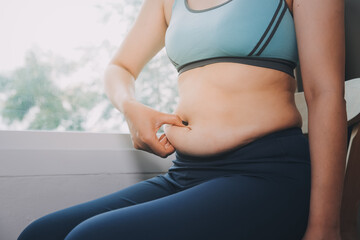 fat woman, fat belly, chubby, obese woman hand holding excessive belly fat with measure tape, woman diet lifestyle concept