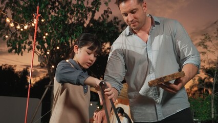 Family gather celebrate holiday, Adorable child grill food for family member. Outdoor camping...