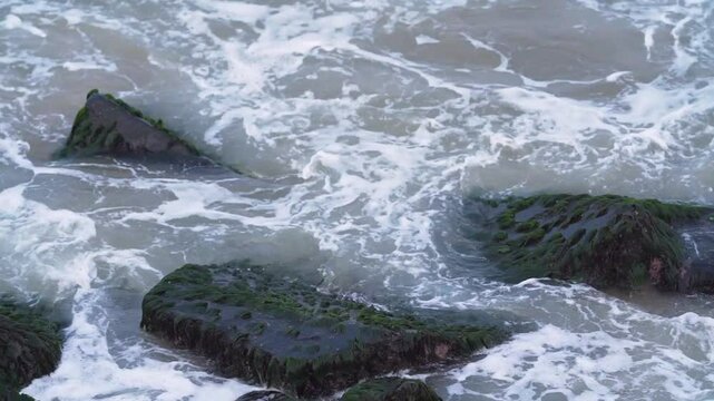water flowing into the sea moss on rock