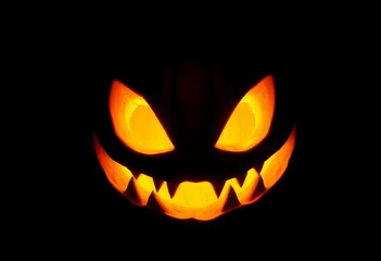 Naklejka premium detailed close up of a Halloween pumpkin with a menacing grin, illuminated from within, on a jet black background create with ai