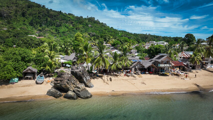 Naklejka premium Aerial view of Nosy Komba Island showcasing lush greenery, sandy beaches, and traditional dwellings along the coastline