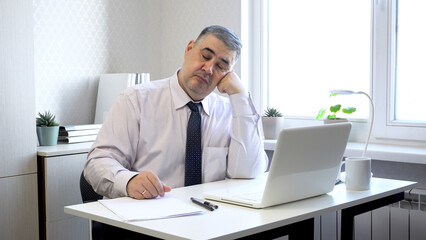 Man Napping at Office Desk with Head Resting on Hand