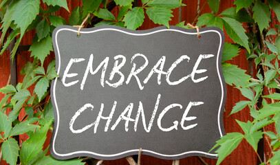 Embrace change symbol. Concept word Embrace change on chalk blackboard. Beautiful red background with plants. Business and Embrace change concept. Copy space