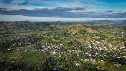 Aerial view of lush greenery and hills on Nosy Be Island in Madagascar showcasing the natural beauty and local settlements