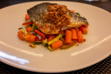 Delicious sea bass fillet served on a combination of fresh vegetables