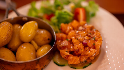 Salmon tartare with baked potatoes and salad