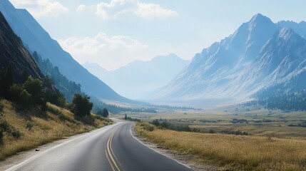 Fototapeta premium A winding road cuts through a scenic valley, leading towards majestic mountains in the distance.