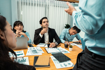 Diverse group of business analyst team analyzing financial data report paper on office table. Chart and graph dashboard by business intelligence analysis for strategic marketing planning Habiliment