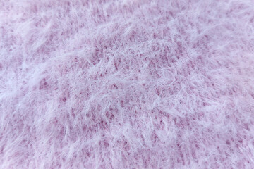 Lilac plush knitted fabric texture close up. Fluffy and soft cozy fabric background. 