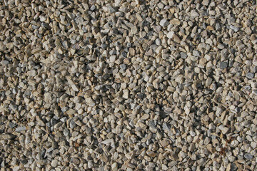 Grey pebble stones texture top view. Gravel road background. Rubble stones surface close up