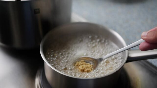 A closeup of fresh, perfectly cooked oats on a spoon, with steam rising, evoking warmth. Steam rises from fluffy oatmeal, highlighting its delightful texture and warmth. Slow motion.