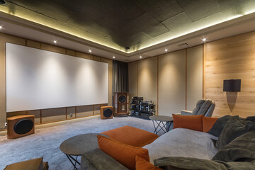 The interior of a home theater with modern equipment. Soft flooring, sofas and armchairs .for...