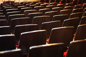 Empty chairs or seats at cinema or theater, concert hall with dramatic lighting and shadow