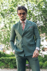 elegant young man with sunglasses holding hand in pocket