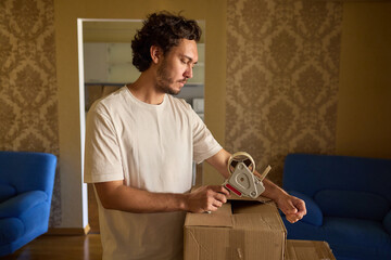 A person is packing a moving box in a cozy, inviting, and comfortable home setting