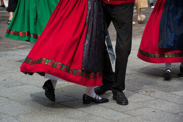Closeup of legs of traditional alsatian dancers with colorful costume dancing in the street