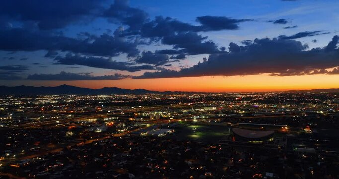 Lively cityscape of modern Phoenix, Arizona, the USA in the evening. Beautiful metropolis under orange-blue sky with clouds.