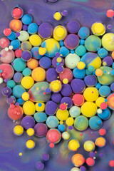 Colorful patterns of floating spheres on a vibrant purple background showcasing a playful, abstract art style