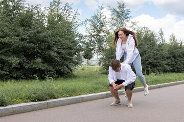 Obraz premium Loving couple of young girl and man are walking and having fun in park on warm summer day. High quality photo