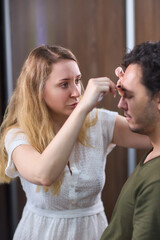 A man with makeup being applied, showing a closeup of the process focusing on his eyebrows