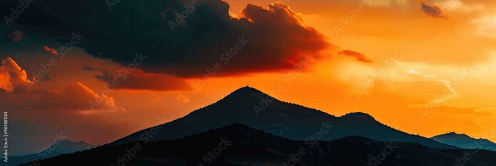 Poster Silhouette of a Mountain Against a Vibrant Orange Cloudy Sky at Dusk