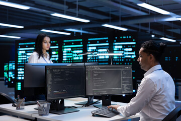 Coworkers in data center using computers to find firewall misconfigurations affecting servers. Colleagues in server room checking systems bottlenecks on PC leading to sluggish data transfer rates