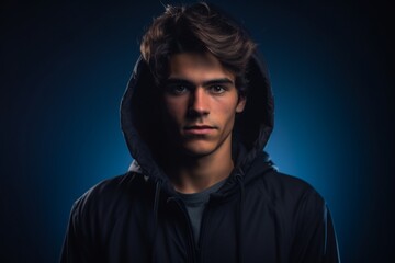 Naklejka premium A young man is wearing a black hoodie and is looking directly at the camera