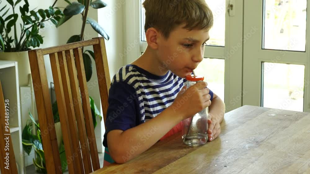 Wall mural Kid drinks water at the kitchen