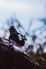 Wooden rosary with cross - with bokeh in background