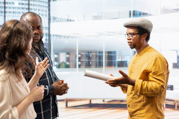 Clients and realtor touring a modern office space for relocation, reviewing modern property blueprints and plans. Business owner negotiating high class urban building investment strategy.