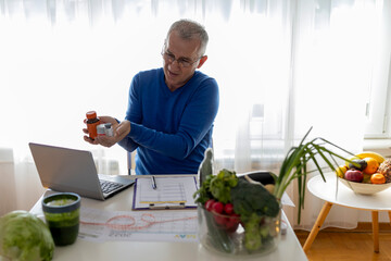 Male nutritionist working with a client on video call from a laptop at home