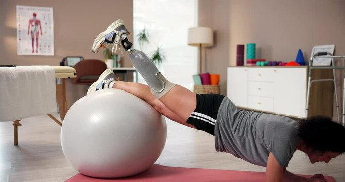Woman, fitness and prosthetic leg as person with a disability at sport center in physical therapy. Female patient, recovery and training with gym ball, exercise or wellness at rehab clinic as amputee